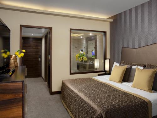 a hotel room with a bed and a television at Dan Carmel Haifa in Haifa