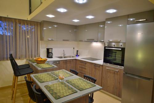 a kitchen with a table and a stainless steel refrigerator at Balcony Rooms in Elafonisi