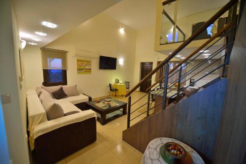 a living room with a couch and a stair case at Balcony Rooms in Elafonisi