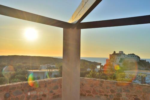 a view of a castle from a window with the sunset at Balcony Rooms in Elafonisi