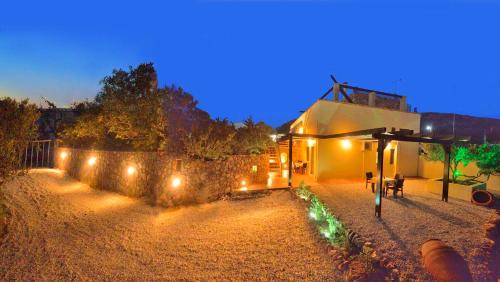 a house with lights on the side of it at night at Balcony Rooms in Elafonisi