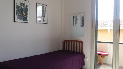 um quarto com uma cama e quadros na parede em Splendido Appartamento 50mt dal mare em Marzamemi