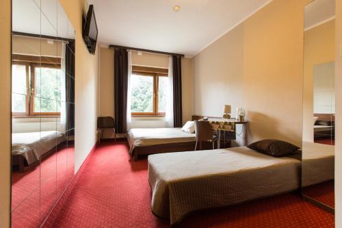 a hotel room with two beds and a mirror at Villa Ventana Poznań City Free Parking 696-890-000 Śniadanie w Cenie in Poznań