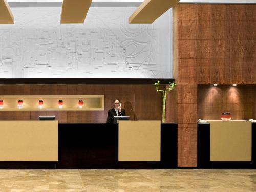 a man standing at a podium in a lobby at Dan Carmel Haifa in Haifa