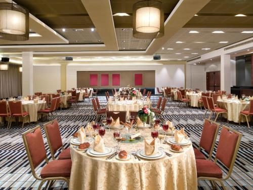 a banquet hall with round tables and chairs at Dan Carmel Haifa in Haifa
