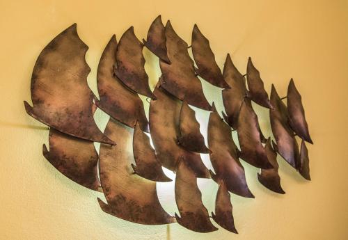 a metal leaf wall art on a wall at Piazza Ginnasio Affittacamere in Alghero