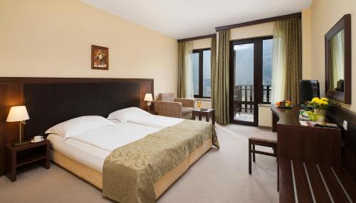 a hotel room with a bed and a balcony at Balneo Complex Saint Spas in Velingrad
