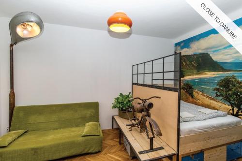 ブダペストにあるExtra Design Flat Close to Danubeの緑のベッドとビーチの絵画が備わるベッドルーム1室