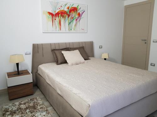 a bedroom with a bed and a painting on the wall at Luxury Apartments Beauty Gardens in Sirmione