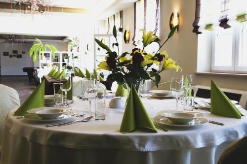 a table with a white table cloth and a vase of flowers at Centrum Restauracyjno-Hotelowe Florres in Pawłowiczki