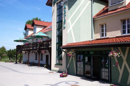 a group of buildings on a street with flowers at Centrum Restauracyjno-Hotelowe Florres in Pawłowiczki