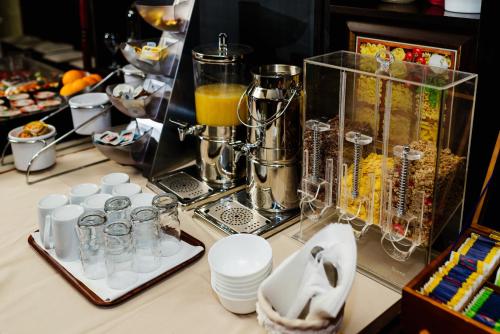 un bancone con un frullatore e alcune tazze e bevande di Pensiunea Casa Vera a Târgu Jiu