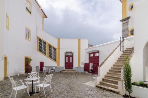 a courtyard of a white building with a red door at Casa Morgado Esporao in Évora