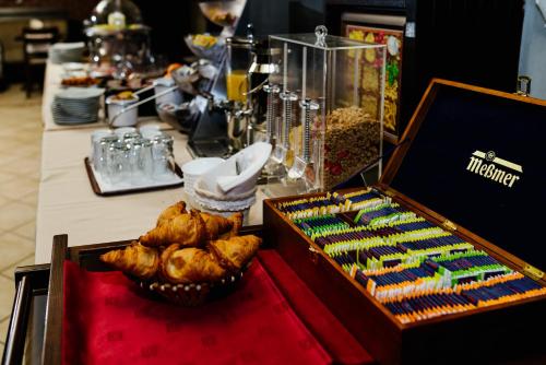 un buffet con pasticcini e una scatola di muffin di Pensiunea Casa Vera a Târgu Jiu