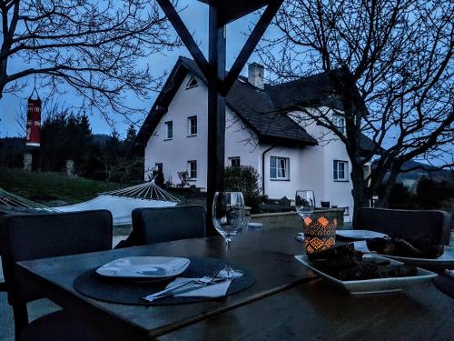 a table with a glass of wine and a house at Vila na Skalce in Česká Kamenice