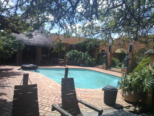 a swimming pool in a yard with a brick building at Emalahleni Castle in Witbank