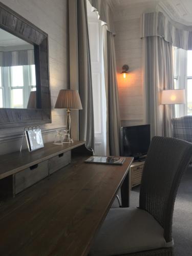 a hotel room with a desk and a mirror at Glenburnie House in Oban