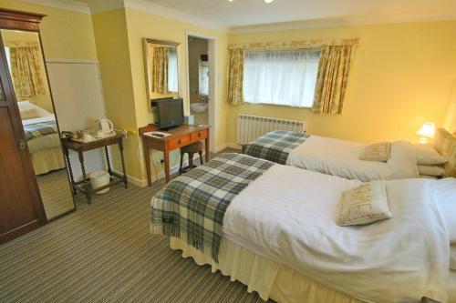 a hotel room with two beds and a television at Calcutts House in Ironbridge