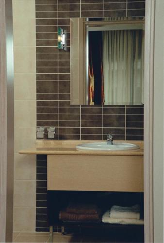 a bathroom with a sink and a mirror at Hotel Makedonia in Veria
