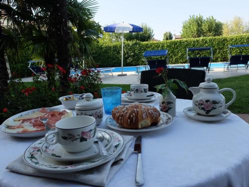 un tavolo con tazze e piatti di cibo sopra di Hotel Bolero a Sirmione