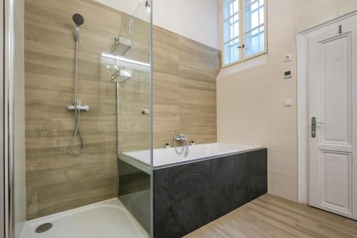 a bathroom with a glass shower and a sink at H75 Apartments Kosice Centre in Košice