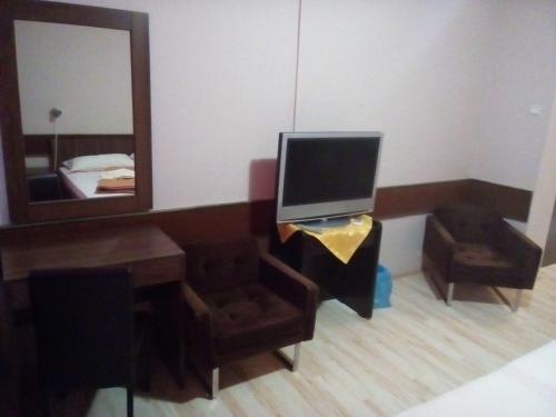 a living room with a tv and a mirror at Restoran sa prenoćištem Žitište in Žitište