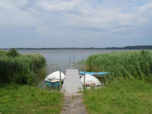 two boats are docked at a dock on a lake at Ferienwohnungen direkt am Schmollensee in Bansin