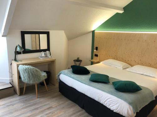a bedroom with a bed with two green pillows at Best Western Bridge Hotel Lyon East in Jons