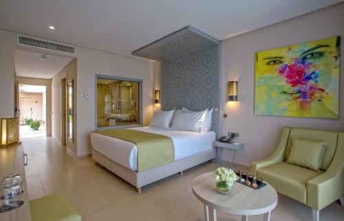 um quarto de hotel com uma cama e uma cadeira em Be Live Collection Marrakech Adults Only All inclusive em Marraquexe