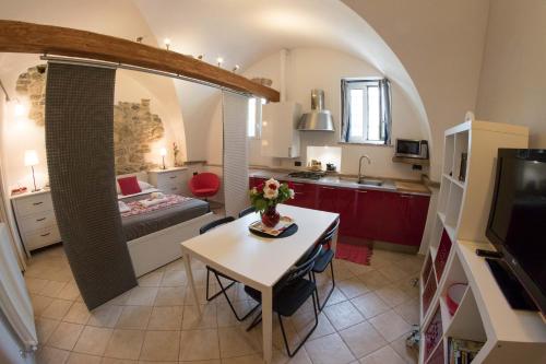 a kitchen and a living room with a table in a room at Il Convento sul Mare in Santo Stefano al Mare