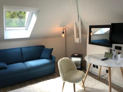 a living room with a blue couch and a table at Best Western Bridge Hotel Lyon East in Jons