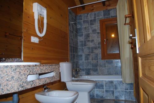 ein Badezimmer mit einem WC, einem Waschbecken und einer Badewanne in der Unterkunft Hotel Piedra in Perlora