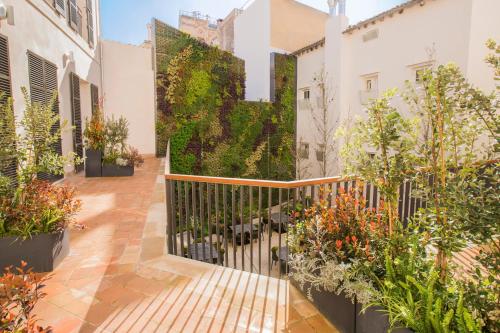 een binnenplaats met planten en een hek bij ICON Rosetó in Palma de Mallorca