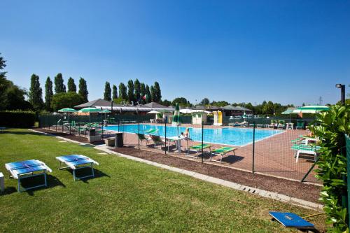 una piscina con sillas y sombrillas en un parque en Centro Turistico Città di Bologna en Bolonia