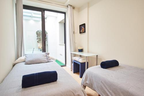 2 camas en una habitación con ventana en Setefilla Deluxe Suite by Valcambre, en Sevilla