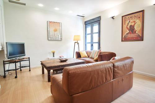 a living room with a couch and a tv at Setefilla Deluxe Suite by Valcambre in Seville