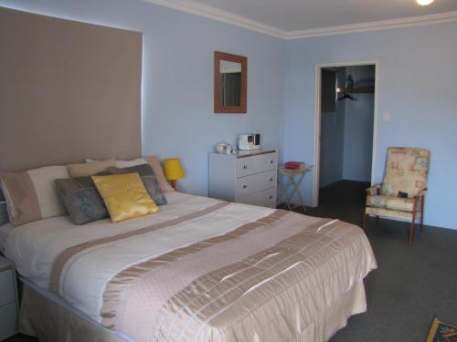 a bedroom with a large bed and a chair at Ocean View Retreat in Jurien Bay