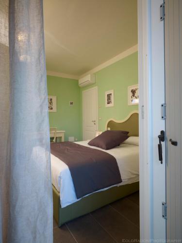 a bedroom with a bed with green walls at Locanda Alla Mano in Forlimpopoli