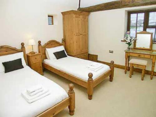A bed or beds in a room at South Stable Cottage 