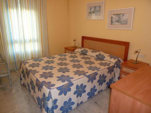 a bedroom with a bed with a blue and white blanket at Casinomar in Benalmádena