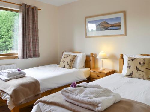 A bed or beds in a room at Rivendell Cottage 