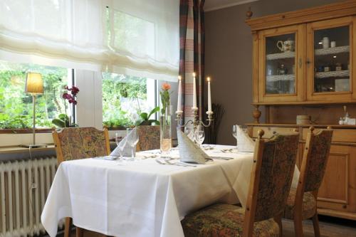 a dining room with a white table and chairs at Hotel zur Post in Deudesfeld