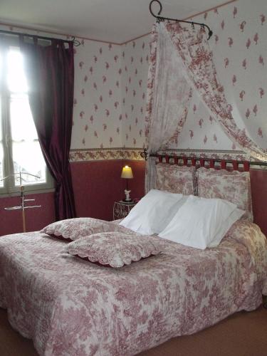 une chambre avec un grand lit à baldaquin dans l'établissement Relais Saint Louis, Logis, à Bellême