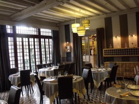 a dining room with tables and chairs in a restaurant at Relais Saint Louis, Logis in Bellême