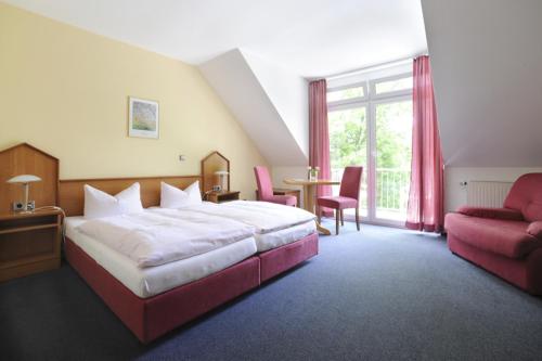 Hotel zur Post في Deudesfeld: غرفه فندقيه بسرير وطاولة وكرسي