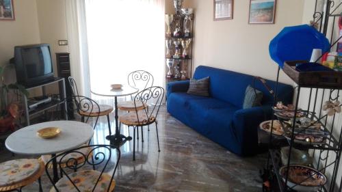 a living room with a blue couch and a table and chairs at Agave in Reggio Calabria