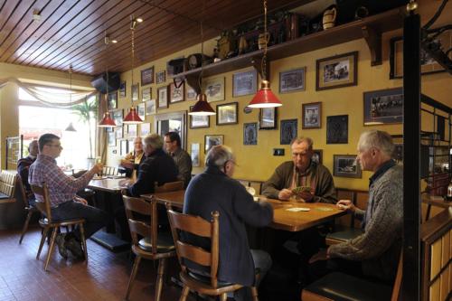 a group of people sitting at a table in a restaurant at Hotel zur Post in Deudesfeld