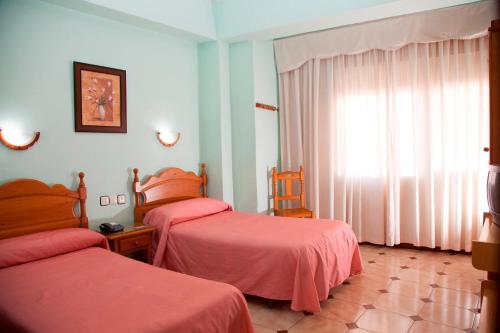 Postel nebo postele na pokoji v ubytování Hostal París