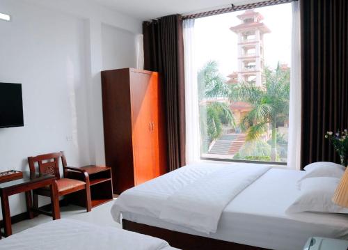 a bedroom with two beds and a large window at Sunflower Hotel in Ninh Binh