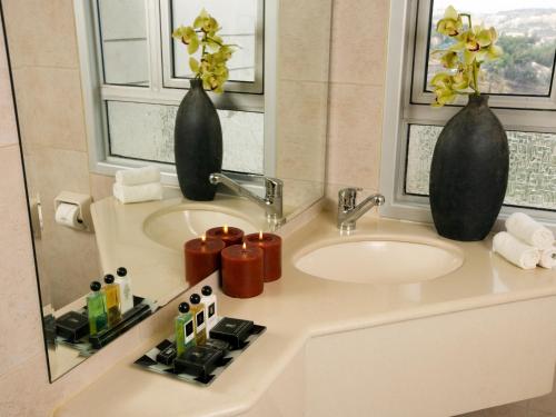 a bathroom with a sink and two vases at Dan Boutique Hotel Jerusalem in Jerusalem